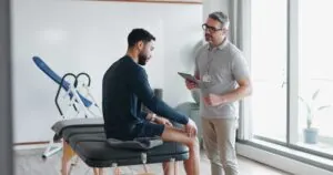 Physical Therapy patient explaining his knee pain to a physician