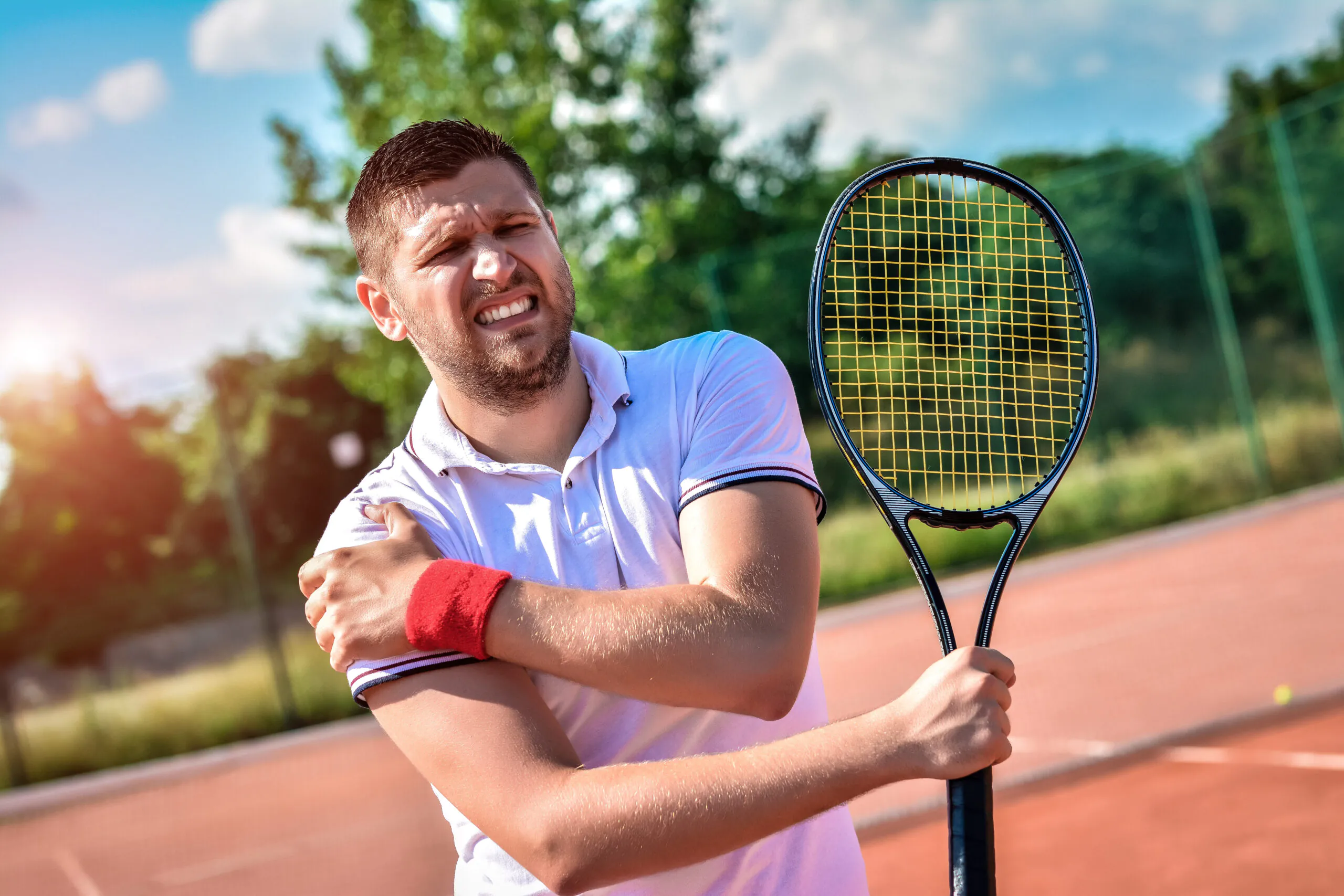 Shot of a tennis player with a shoulder injury on a clay court