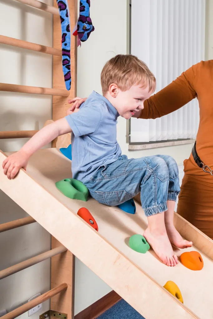 Pediatric Sensory Integration Therapy - a boy on climbing wall