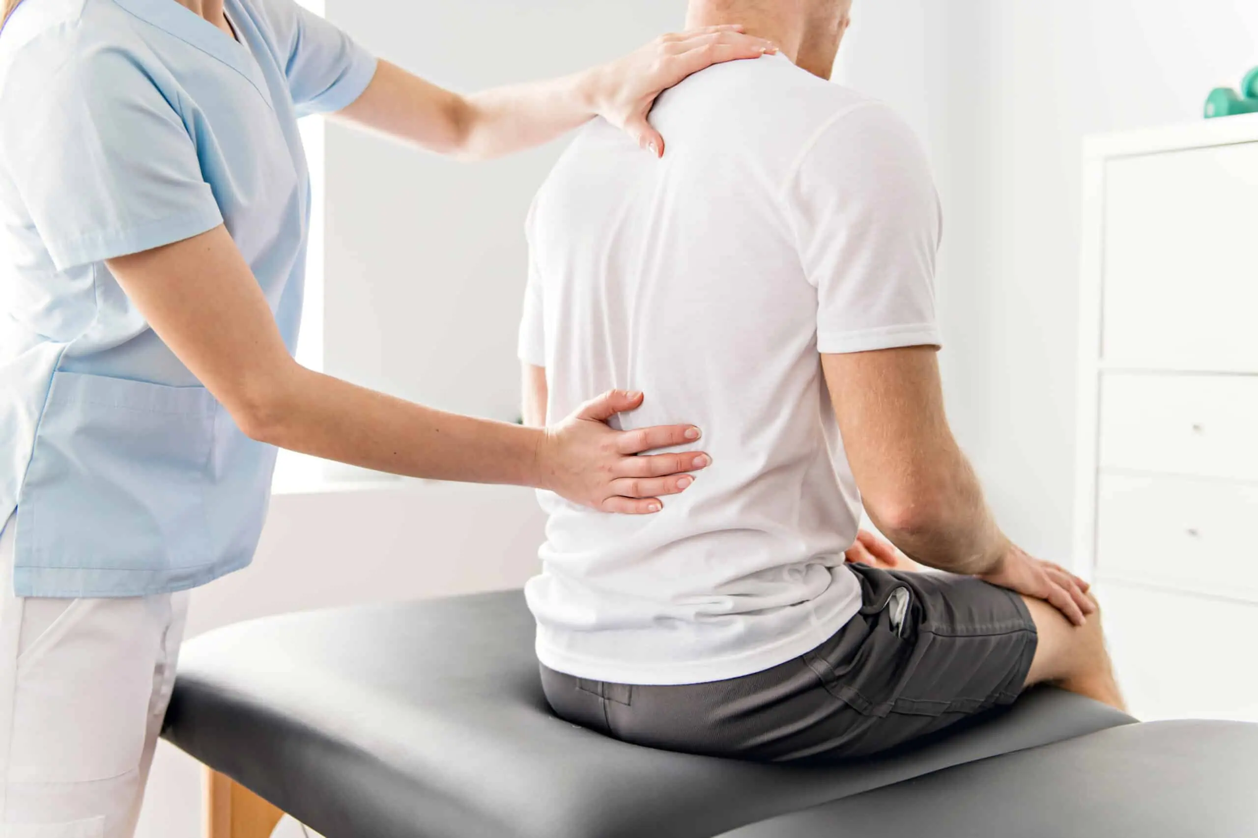 A Patient at the physiotherapy doing physical exercises with his therapist