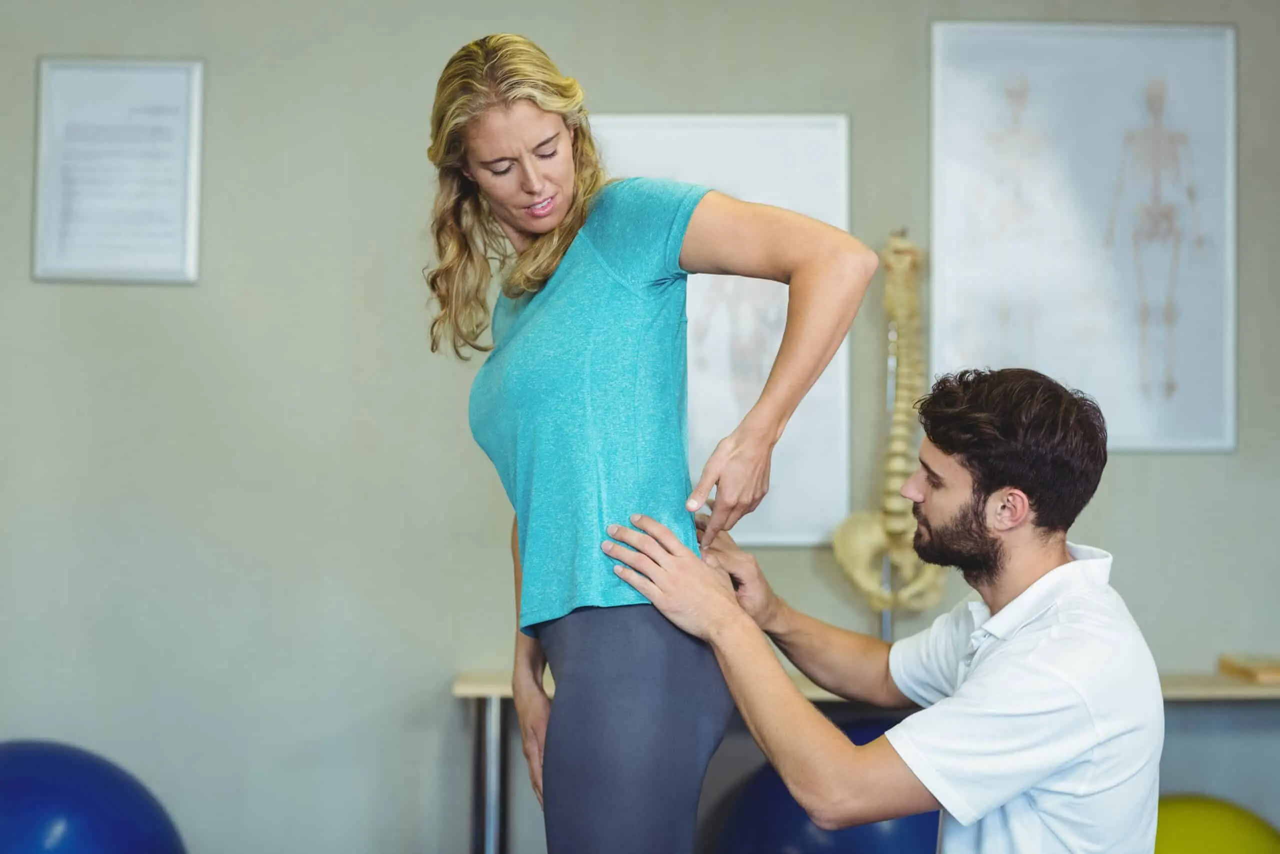 Physiotherapist examining woman's back