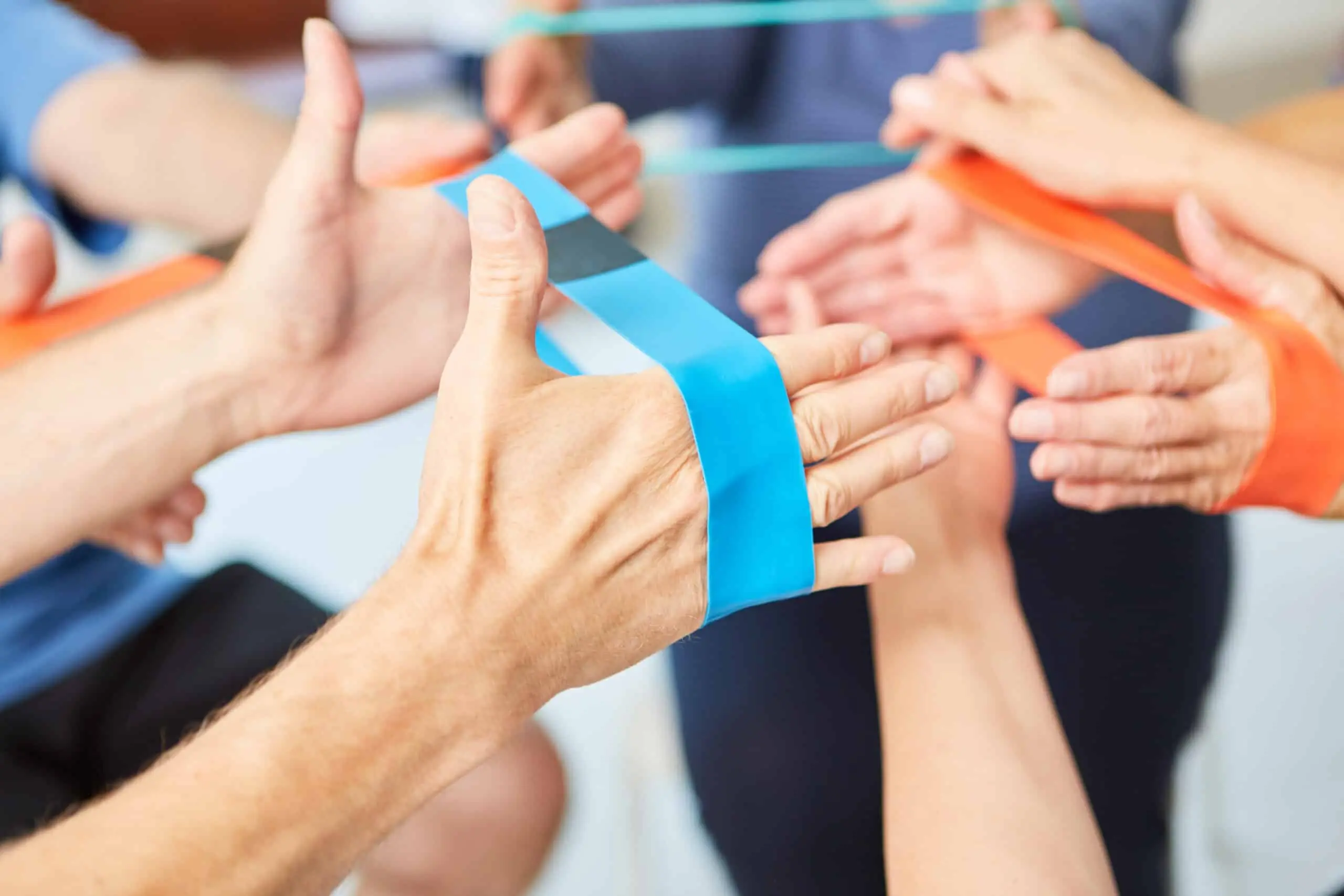 Hands do exercise with the elastic band as physiotherapy in rehab