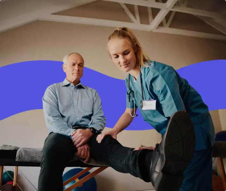 an older patient having his knee treated by a femal PT