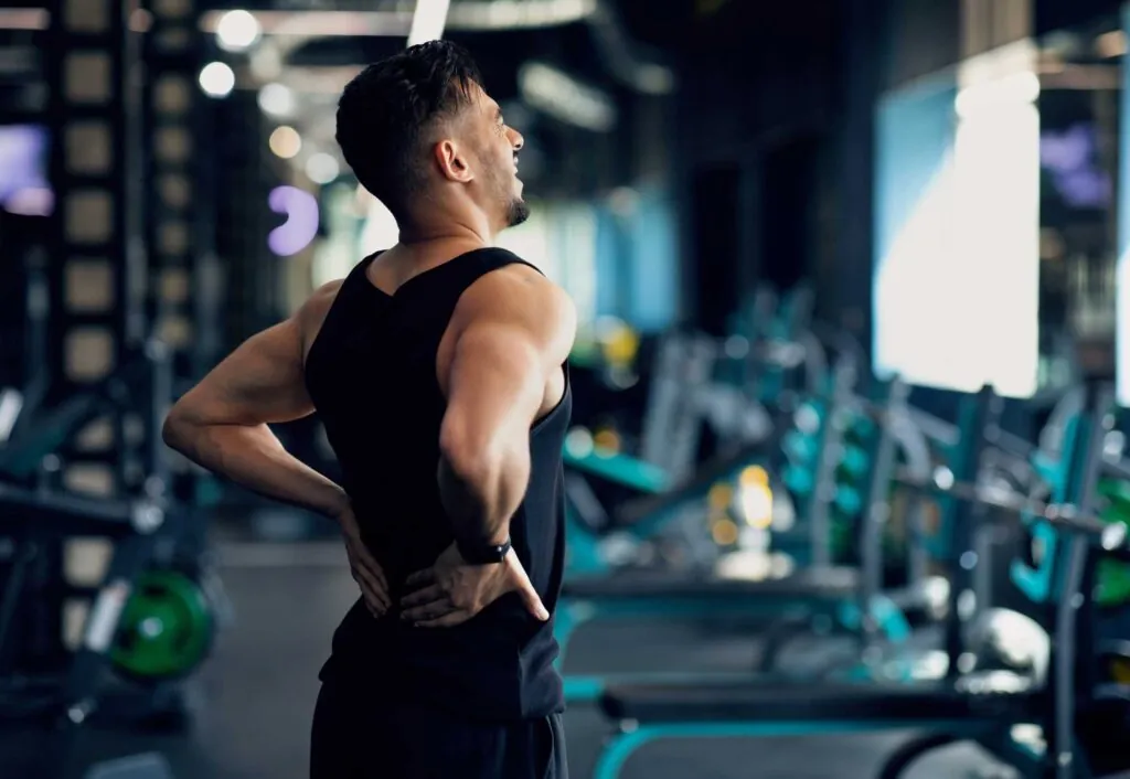 Portrait Of Young Arab Bodybuilder Suffering Lower Back Pain At Gym