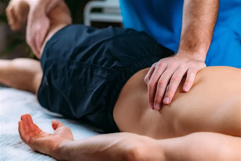 a PT massaging the back of a male patient