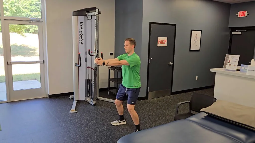 Male Patient performing a Pallof Press  in a medical facility gym