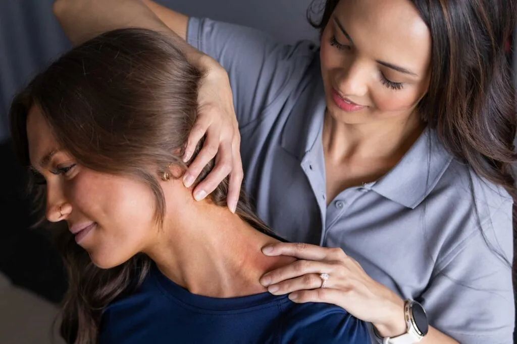 Female PT stretching a patients neck to test for neck pain symptoms