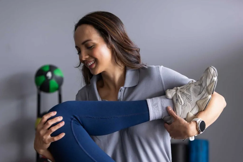 Close-up of PT stretching a patients leg to reduce knee pain