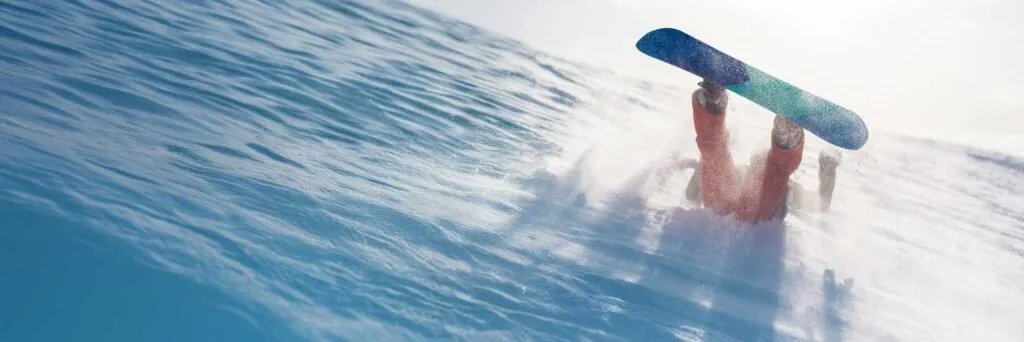 Snowboarder upside down in the snow on a mountain, dynamic action style with bright blue and white colors. Great for sports, adventure ads, wide banner with copy space.