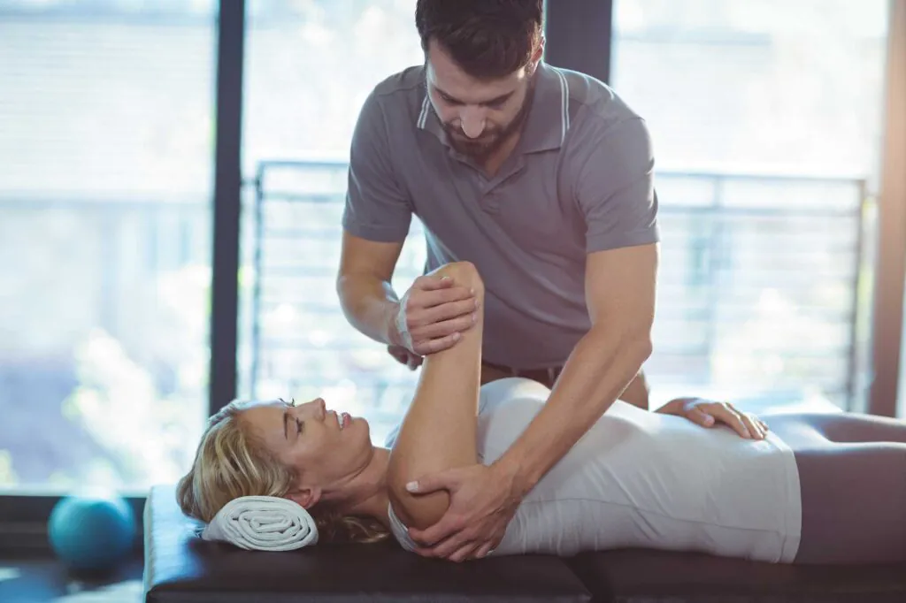 Physiotherapist giving shoulder therapy to a woman