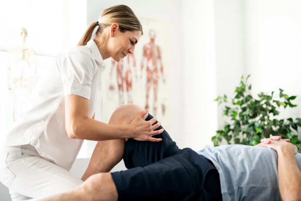 Modern rehabilitation physiotherapy worker with senior client