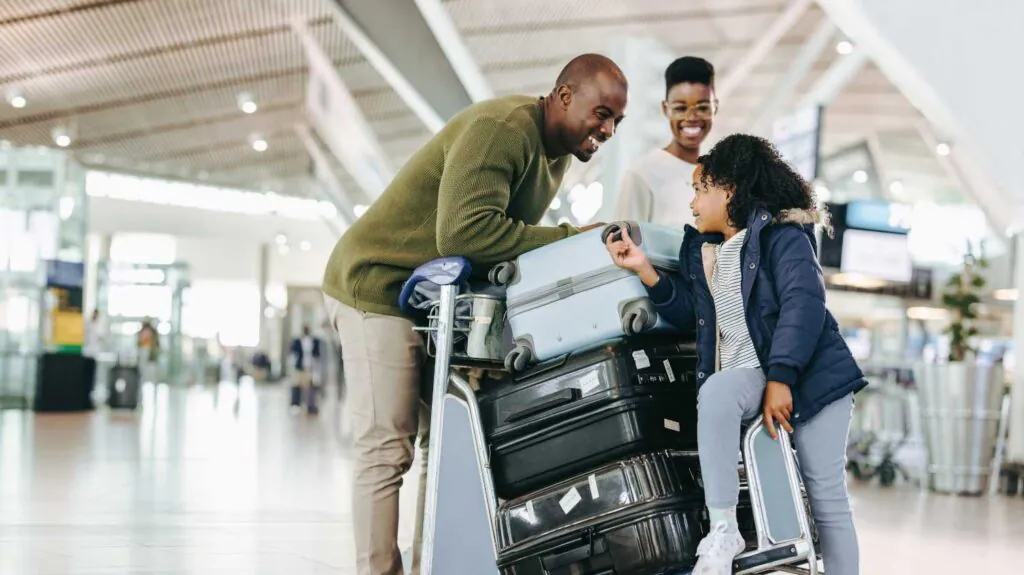 a family at the airport with suitcases ready for vacation