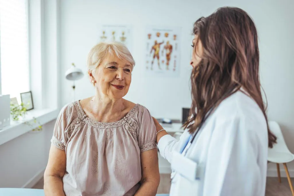 Smiling Elderly Woman During Consultation With Female Doctor in Modern Clinic