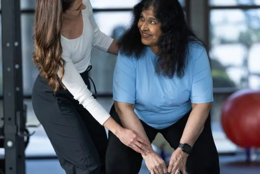 therapy patient doing lifts with kettle bell with PT supervising